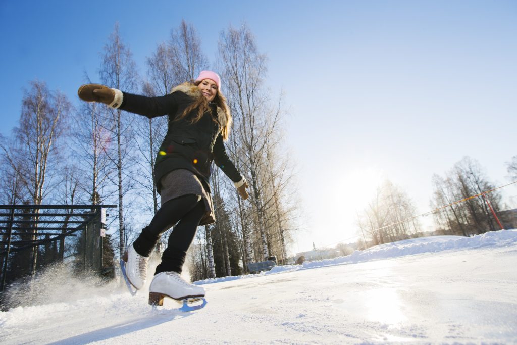 Nainen luistelee aurinkoisessa säässä.