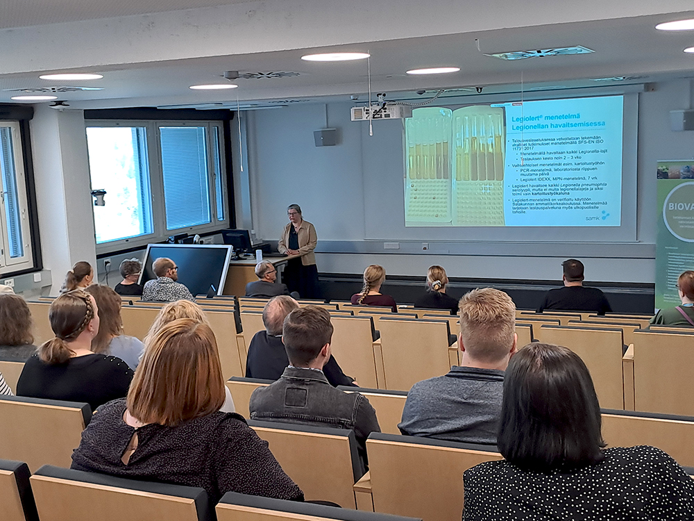 Seminaariyleisöä auditoriossa takaapäin kuvattuna.