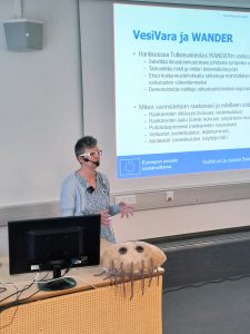 Riika Mäkinen speaks in front of an audience.